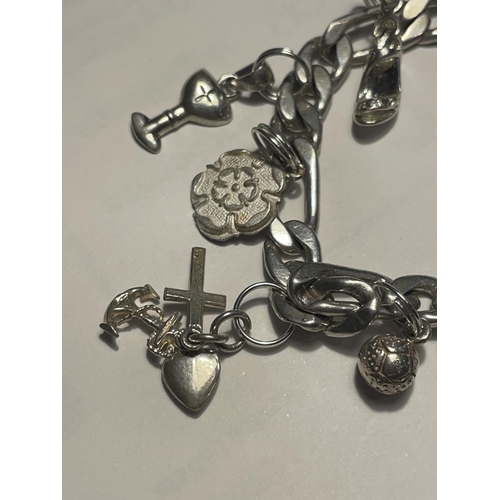 612 - A SILVER CHARM BRACELET WITH HEART PADLOCK AND ELEVEN CHARMS