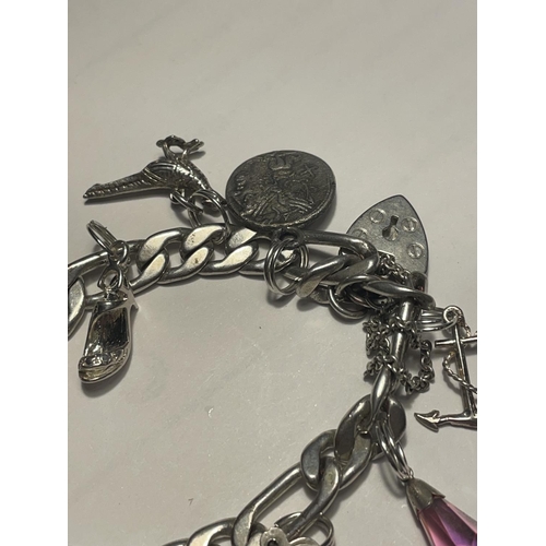 612 - A SILVER CHARM BRACELET WITH HEART PADLOCK AND ELEVEN CHARMS