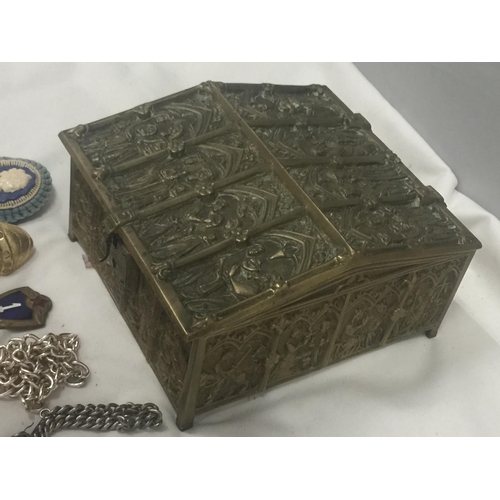 145 - A HEAVY BRASS JEWELLERY BOX EMBOSSED WITH ECCLESIASTICAL IMAGES AND VELVET LINING CONTAINING A QUANT... 