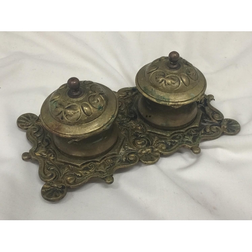 150 - A VINTAGE BRASS INKWELL WITH ORNATE DECORATION INCLUDING ONE LINER