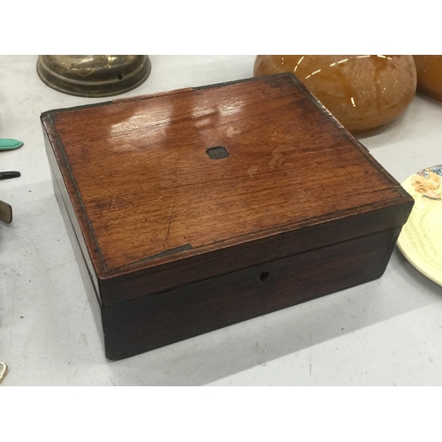 155 - A MAHOGANY BOX CONTAINING A QUANTITY OF ITEMS TO INCLUDE A BRASS SUN DIAL, HIP FLASK, BELT BUCKLE, D... 