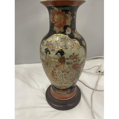23A - AN ORIENTAL LAMP WITH BRASS DETAIL ON A WOODEN BASE