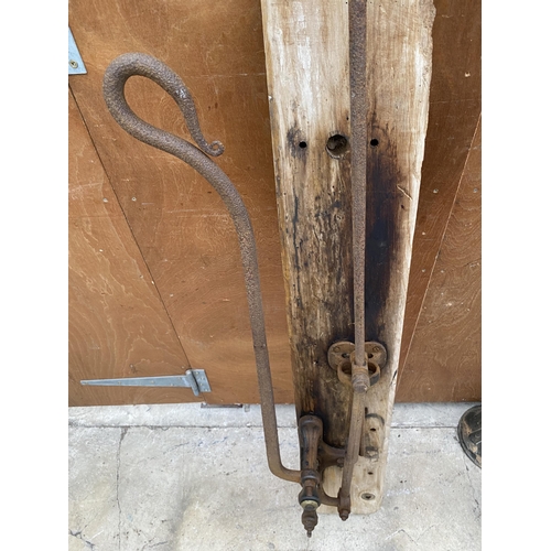 1302 - A VINTAGE CAST IRON WATER PUMP MECHANISM ON A WOODEN BOARD