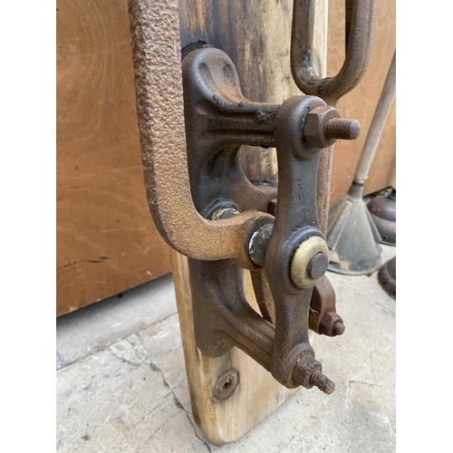 1302 - A VINTAGE CAST IRON WATER PUMP MECHANISM ON A WOODEN BOARD