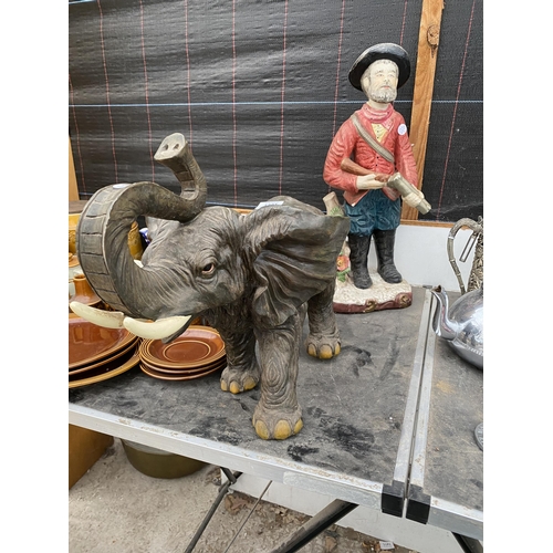 1391 - A RESIN ELEPHANT FIGURE AND A FIGURE OF A MAN WITH A GUN