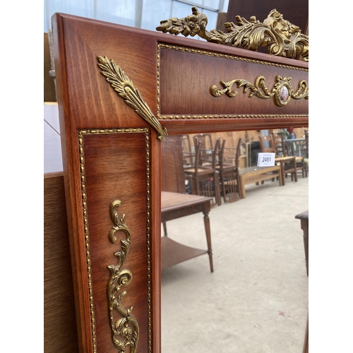 2451 - A MODERN REGENCY STYLE WALL MIRROR WITH APPLIED GILT METAL DECORATION AND TWO SMALL PORCELAIN PANELS... 