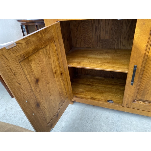 2484 - A MODERN OAK OPEN DISPLAY UNIT WITH THREE TIERS, HAVING TWO PANELLED DOORS TO THE ASE, WITH METALWAR... 