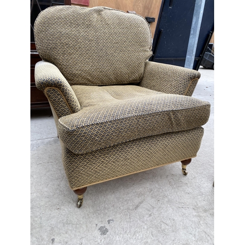 2477 - A VICTORIAN STYLE EASY CHAIR ON TURNED FRONT LEGS WITH BRASS CASTERS