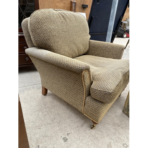 2477 - A VICTORIAN STYLE EASY CHAIR ON TURNED FRONT LEGS WITH BRASS CASTERS