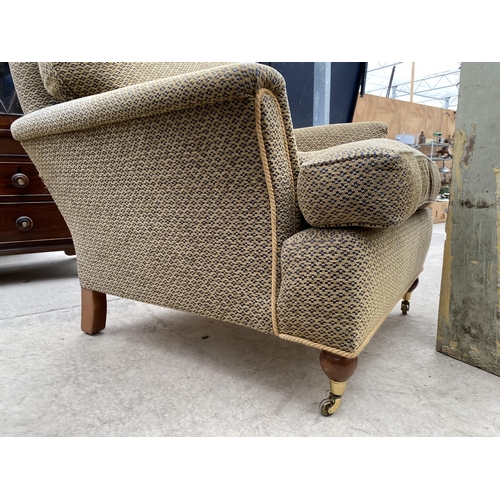 2477 - A VICTORIAN STYLE EASY CHAIR ON TURNED FRONT LEGS WITH BRASS CASTERS