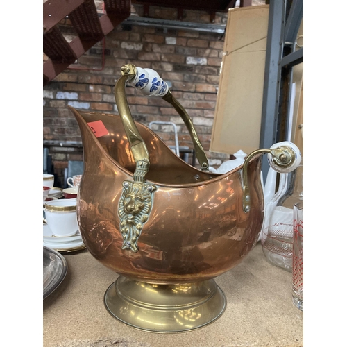 284 - A COPPER FOOTED COAL SCUTTLE WITH BRASS HANDLE AND CERAMIC DETAIL