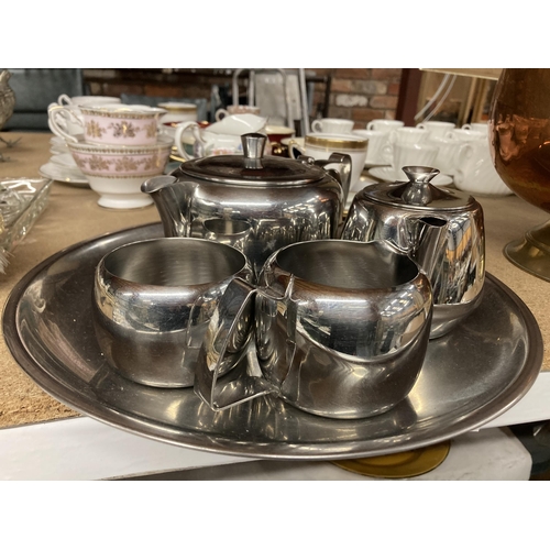 285 - AN OLDE HALL STAINLESS STEEL TEASET TO INCLUDE A TRAY, TEAPOT, HOT WATER POT, CREAM JUG AND SUGAR BO... 