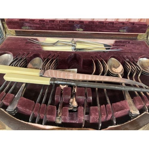 931 - A MAHOGANY CASED SERPENTINE FRONT VINTAGE CANTEEN OF CUTLERY WITH FITTED INTERIOR