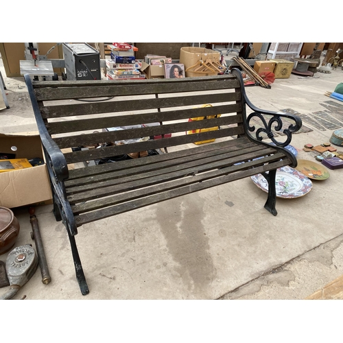 1351 - A WOODEN SLATTED GARDEN BENCH WITH CAST IRON BENCH ENDS