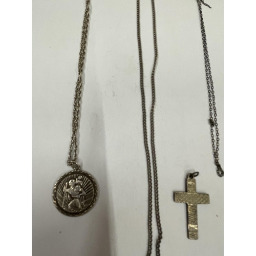 582 - FOUR SILVER NECKLACES WITH A ST CHRISTOPHER AND A CROSS