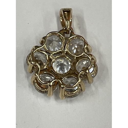 600 - A 10 CARAT GOLD PENDANT WITH A CLEAR STONE FLOWER DESIGN