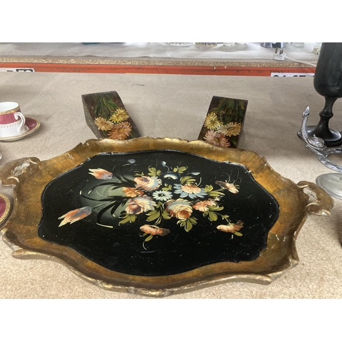 1038 - A VINTAGE PAPIER MACHE TRAY WITH FLORAL PATTERN, TWO DECORATED DOOR WEDGES AND TWO COW BELLS