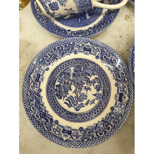 1054 - A LARGE QUANTITY OF BLUE AND WHITE CUPS AND SAUCERS PLUS A CREAM JUG AND SUGAR BOWL