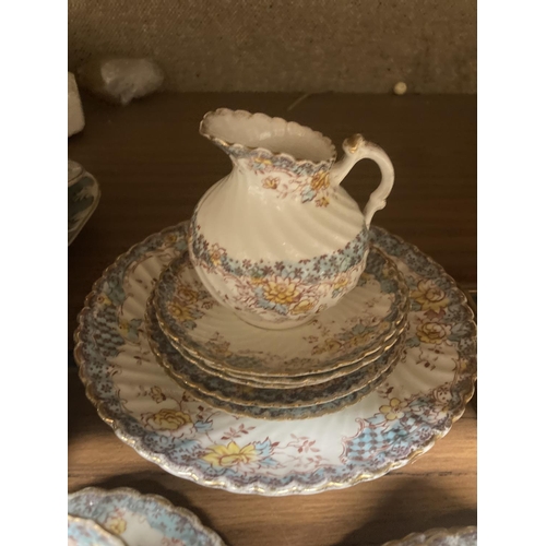 1121 - A CHINA TEASET WITH A BLUE AND YELLOW FLORAL PATTERN TO INCLUDE CUPS, SAUCERS, SIDE PLATES, A CAKE P... 