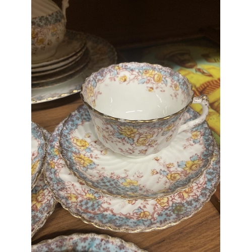 1121 - A CHINA TEASET WITH A BLUE AND YELLOW FLORAL PATTERN TO INCLUDE CUPS, SAUCERS, SIDE PLATES, A CAKE P... 