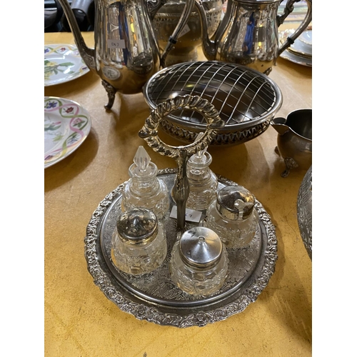 553 - A QUANTITY OF SILVER PLATED ITEMS TO INCLUDE A COFFEE POT, TEAPOT, HANDLED BASKET, BOWL, CRUET SET O... 