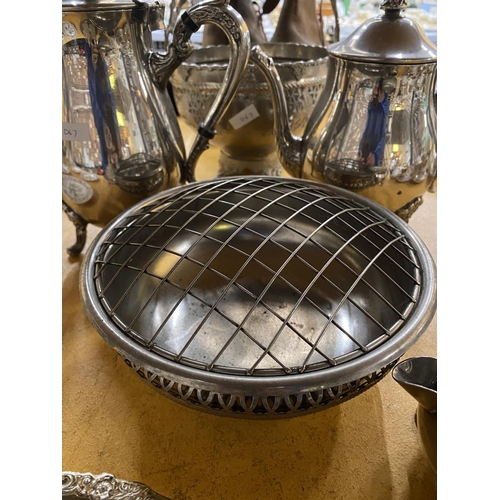 553 - A QUANTITY OF SILVER PLATED ITEMS TO INCLUDE A COFFEE POT, TEAPOT, HANDLED BASKET, BOWL, CRUET SET O... 