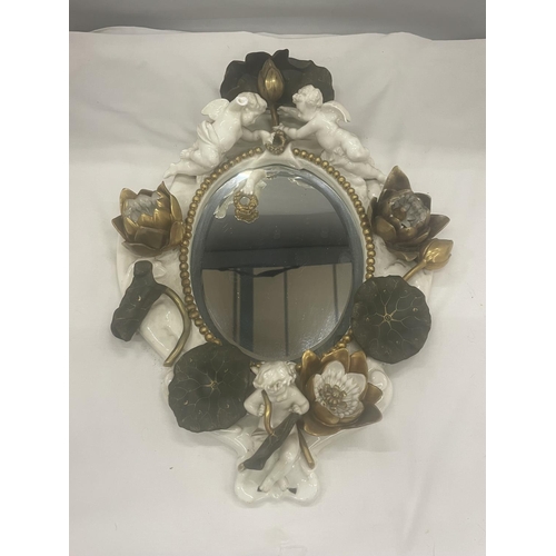 24 - A WHITE AND GILDED CERAMIC MIRROR WITH CHERUB, LILY AND LEAF DESIGN (A/F CHERUBS ARM)