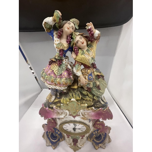 28 - A DECORATIVE FRENCH PORCELAIN MANTLE CLOCK WITH A COURTING COUPLE AND GRAPES DECORATION