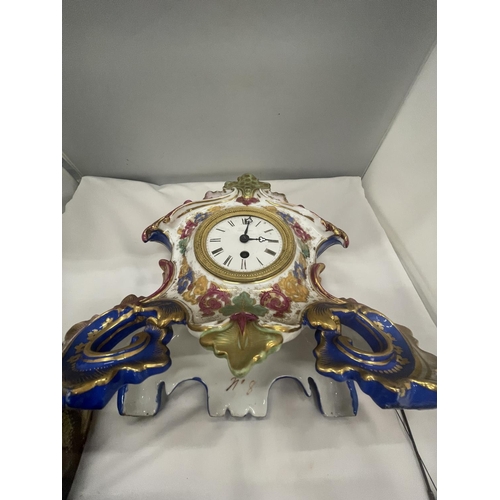 28 - A DECORATIVE FRENCH PORCELAIN MANTLE CLOCK WITH A COURTING COUPLE AND GRAPES DECORATION