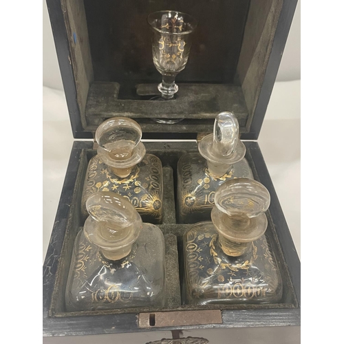 37 - A VINTAGE MAHOGANY LIQUER CASE WITH FOUR DECANTERS AND ONE GLASS COMPLETE WITH LABELLED KEY