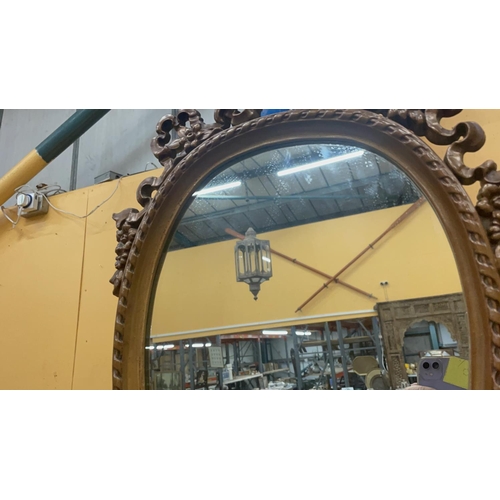 46 - AN ORNATE WOODEN FRAMED MIRROR