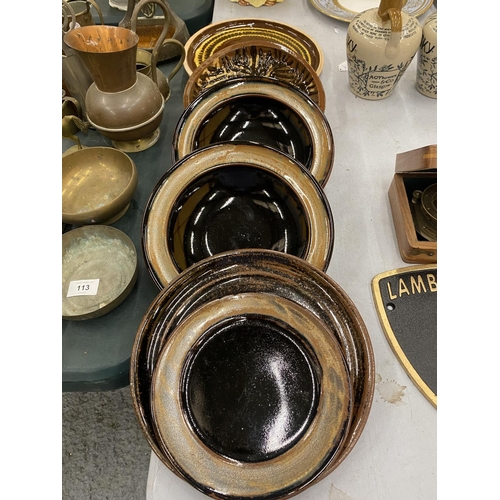 112 - A QUANTITY OF STUDIO POTTERY BOWLS AND PALTES WITH A BROWN GLAZE