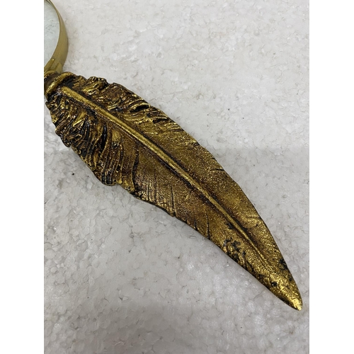 121 - A MAGNIFYING GLASS WITH METAL GILDED 'FEATHER' HANDLE