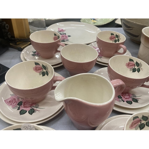 185 - A WADE TEASET IN PINK WITH A ROSE PATTERN TO INCLUDE A CAKE PLATE, CREAM JUG, SUGAR BOWL, CUPS, SAUC... 