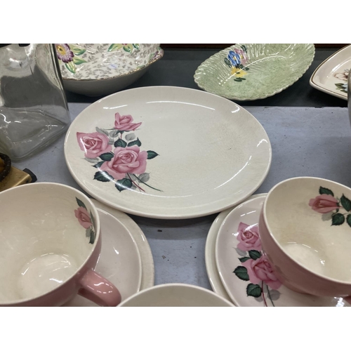 185 - A WADE TEASET IN PINK WITH A ROSE PATTERN TO INCLUDE A CAKE PLATE, CREAM JUG, SUGAR BOWL, CUPS, SAUC... 