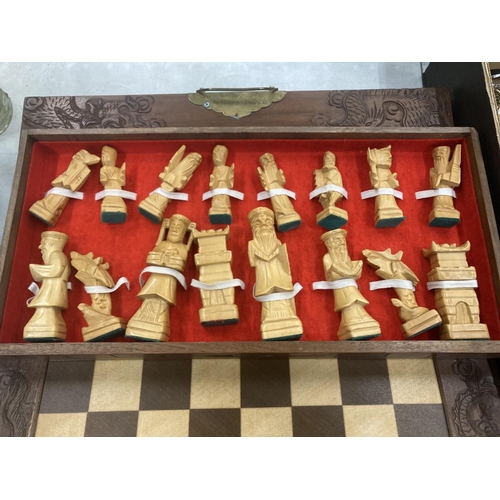 203 - A CHESS SET WITH A WOOD AND RESIN TOP AND WOODEN CHESS PIECES CONTAINED IN DRAWERS, WITH BRASS HINGE... 