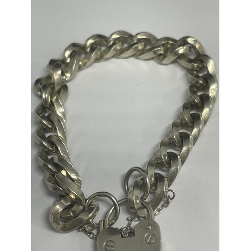 536 - A HEAVY MARKED SILVER BRACELET WITH A HEART LOCK