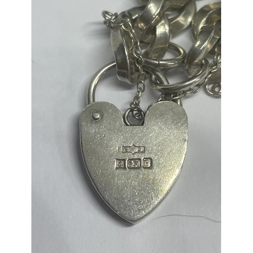 536 - A HEAVY MARKED SILVER BRACELET WITH A HEART LOCK