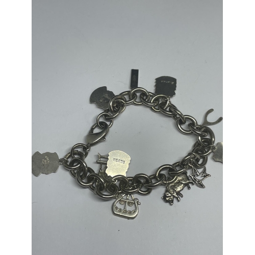 540 - A MARKED SILVER CHARM BRACELET WITH TEN CHARMS