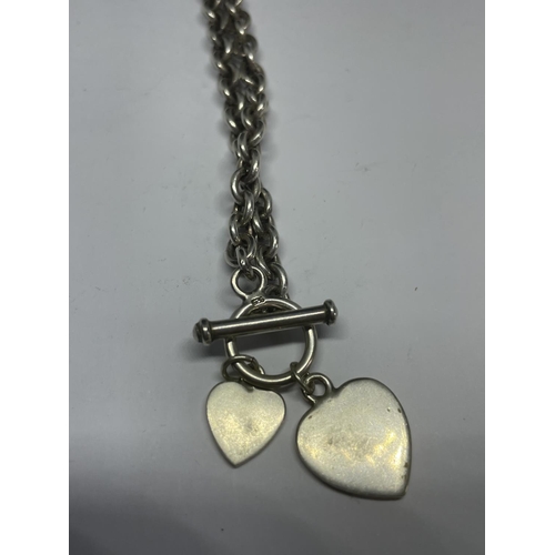 549 - A MARKED SILVER T BAR NECKLACE WITH TWO HEART PENDANTS