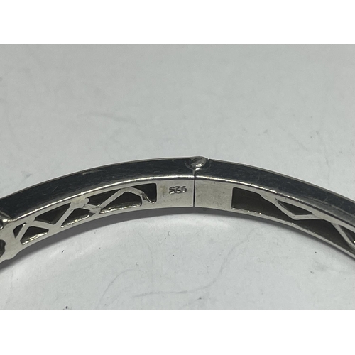 554 - A MARKED SILVER BANGLE WITH A LINE OF NINE NAVAJO STYLE STONES IN A PRESENTATION BOX