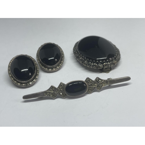 597 - A SILVER BROOCH WITH LARGE DARK STONE, A PAIR OF MATCHING EARRINGS AND A FURTHER BROOCH