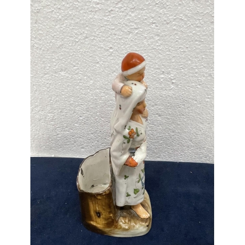 411 - A VINTAGE CONTINENTAL CERAMIC OF A MOTHER AND CHILD WITH MATCH HOLDER AND STRIKER