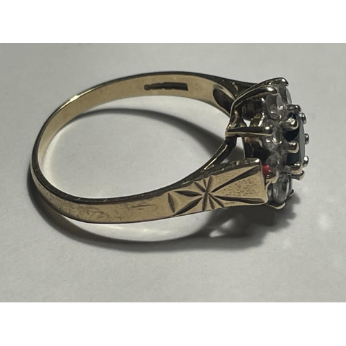 514 - A 9 CARAT GOLD RING WITH A CENTRE SAPPHIRE SURROUNDED BY EIGHT CUBIC ZIRCONIAS SIZE M