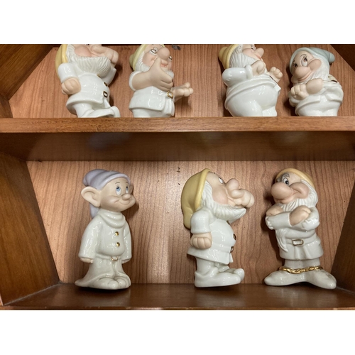 140 - A WOODEN HOUSE SHAPED DISPLAY CASE CONTAINING LENNOX DISNEY MODELS OF SNOW WHITE AND THE SEVEN DWARF... 