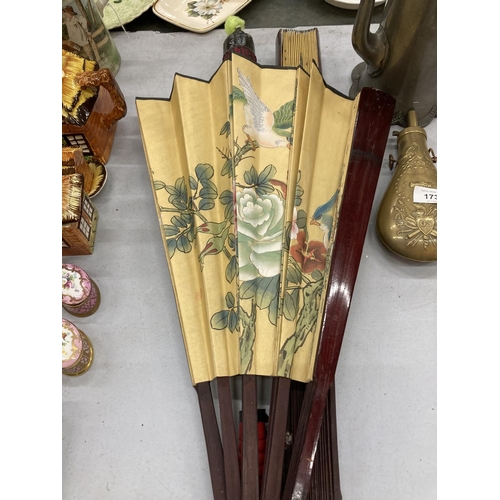 180 - TWO LARGE HANDPAINTED EASTERN FANS AND A HANDPAINTED PARASOL