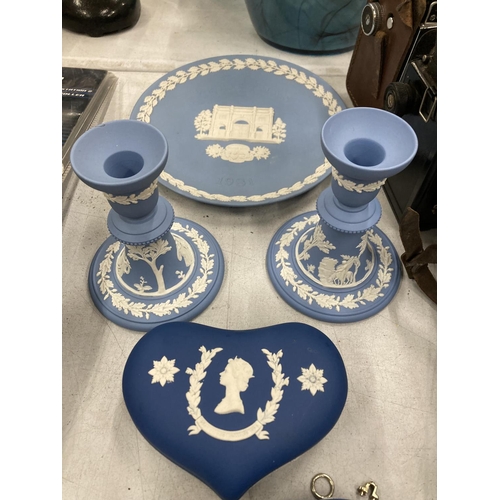 256 - A QUANTITY OF POWDER BLUE AND COBALT BLUE WEDGWOOD JASPERWARE TO INCLUDE TRINKET BOXES, CANDLESTICKS... 