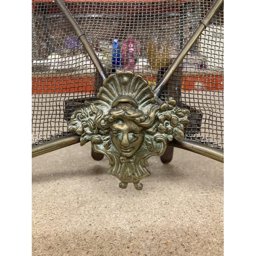 889 - A VINTAGE FIRE SCREEN WITH BRASS MASK DECORATION WIDTH 60CM