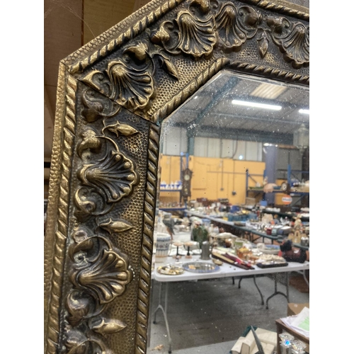 933 - A VINTAGE BRASS OCTAGONAL MIRROR WITH FLORAL AND SHELL EMBOSSED DECORATION 73CM X 44CM