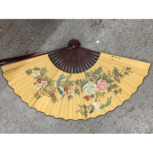 180 - TWO LARGE HANDPAINTED EASTERN FANS AND A HANDPAINTED PARASOL